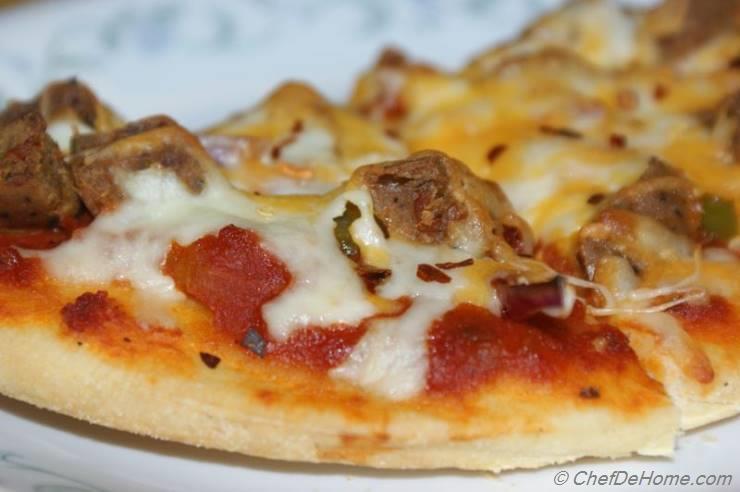 Pizza with smoked sausage, cherry tomatoes, dried chilli, jalapeno