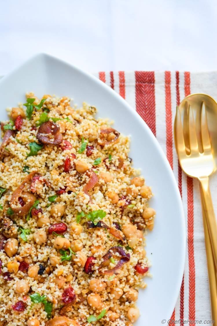 Warm and comforting bowl of Couscous with spiced chickpeas, and caramelized onions, with some festive sweetness and color from cranberries.