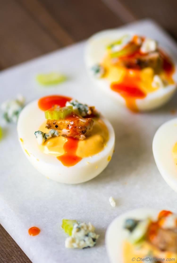 Deviled Egg topped with chicken celery and buffalo hot sauce