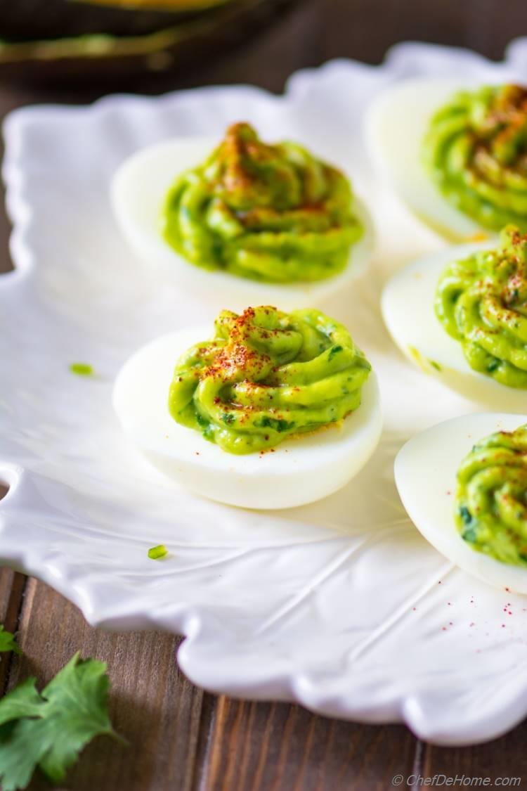 Spicy and healthy deviled eggs topped with avocado sauce